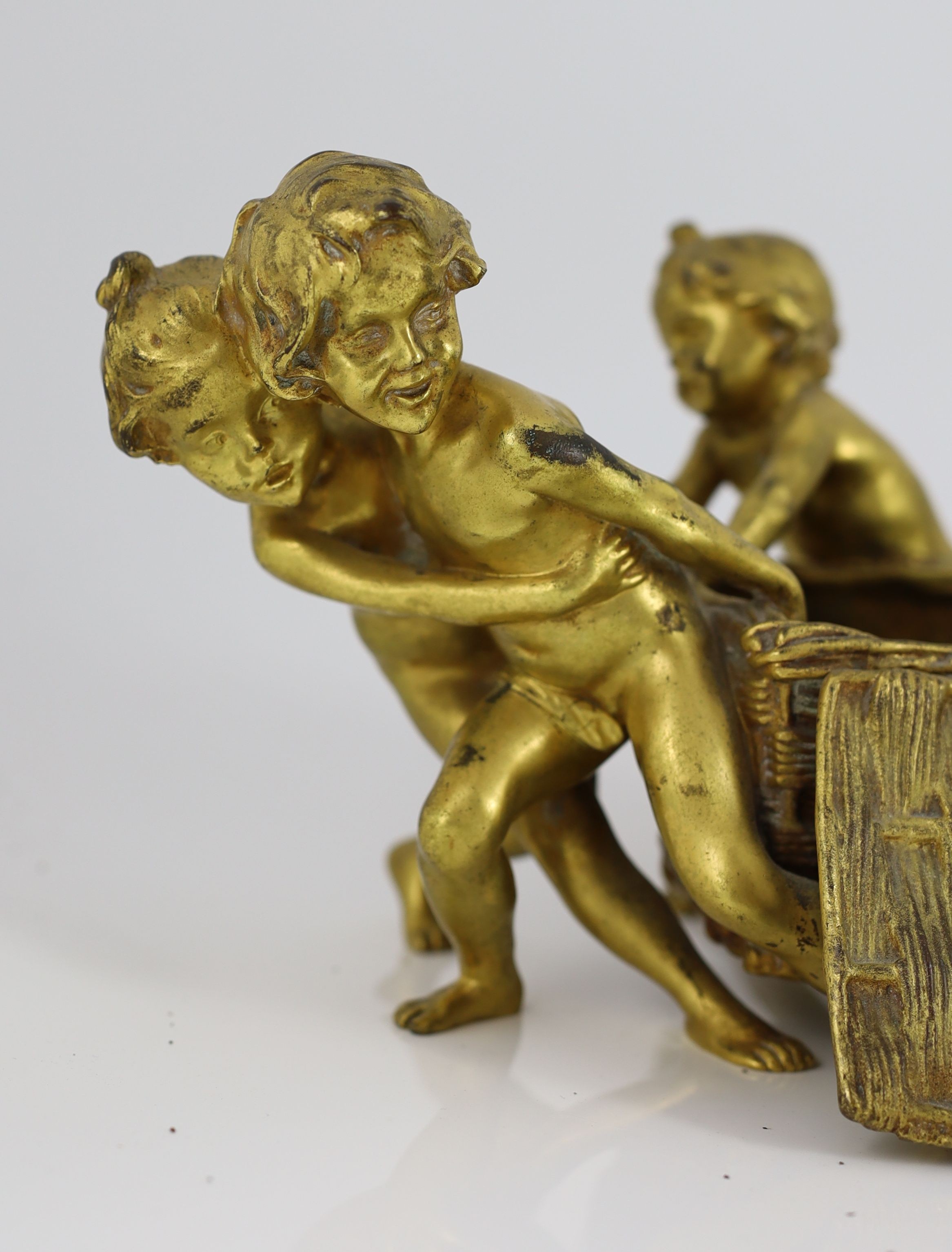 Raoul Francois Larche (French, 1860 - 1912). A set of three ormolu groups of children pushing and pulling large wicker baskets, largest length 45cm height 17cn smaller length 27cm height 16cm